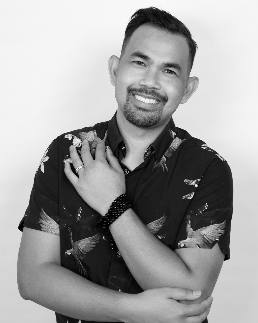 Black and white portrait of Da Ol smiling with hand over heart